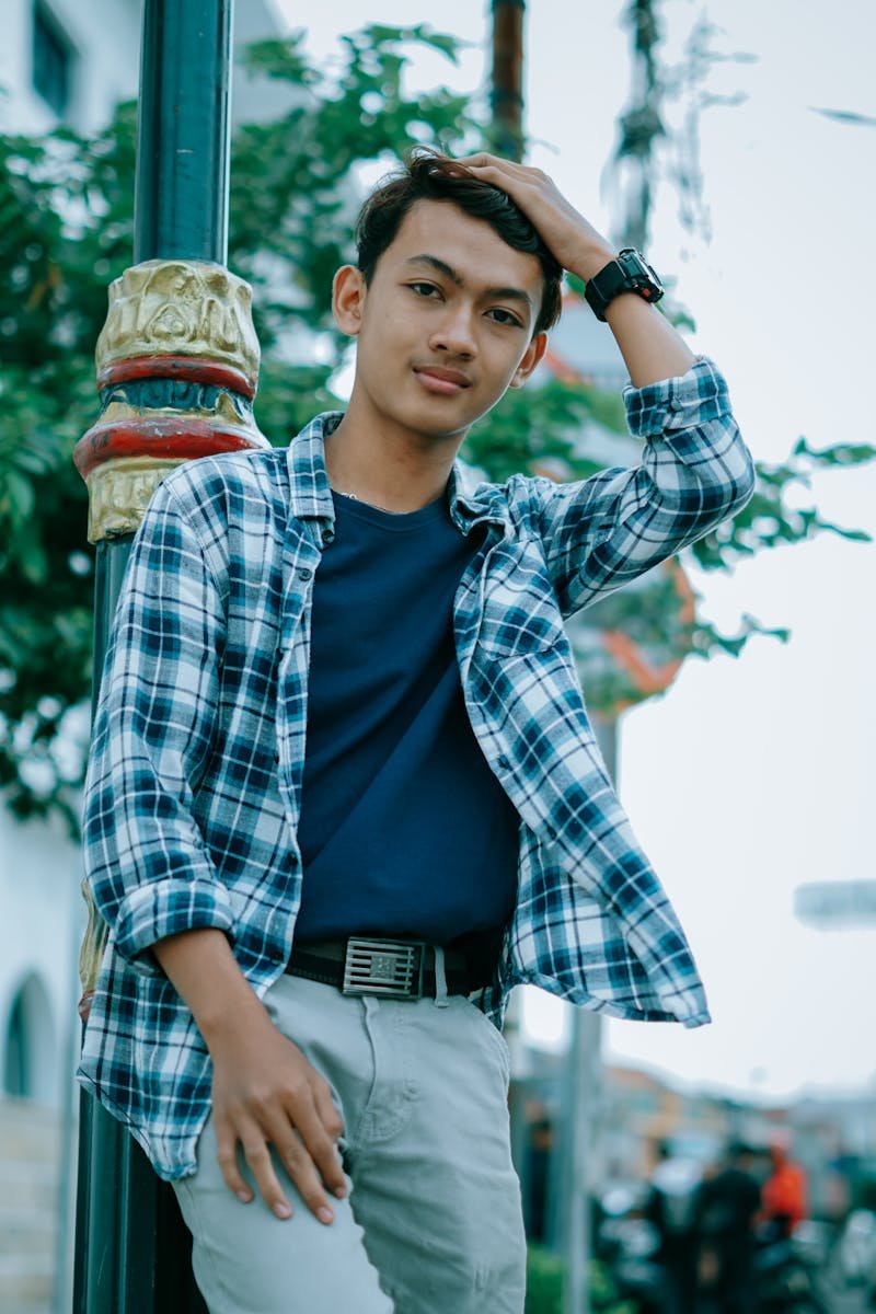 A teenage boy poses confidently with one hand on his head in Cirebon, Indonesia.